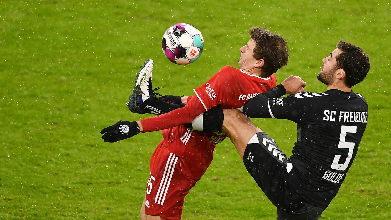 MUNICH,GERMANY,17.JAN.21 - SOCCER - 1. DFL, 1. Deutsche Bundesliga, FC Bayern Muenchen vs SC Freiburg. Image shows Thomas Müller (Bayern) and Manuel Gulde (Freiburg).